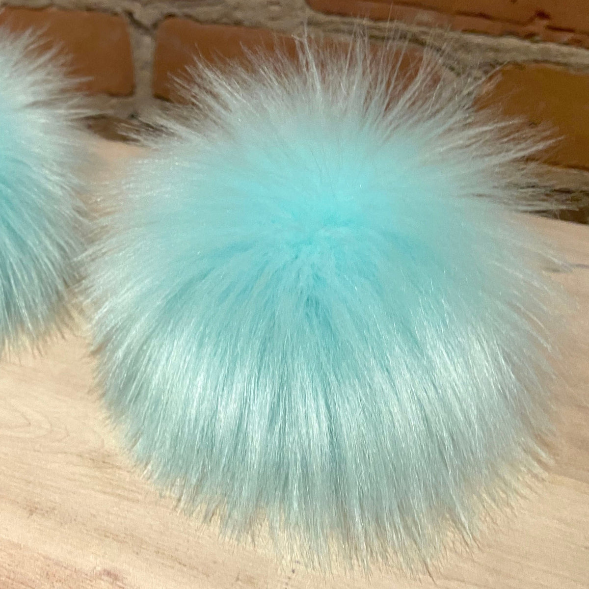 Aqua Hat Pom Sitting on a Table